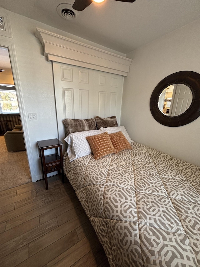 bedroom featuring visible vents, ceiling fan, a closet, and dark wood finished floors