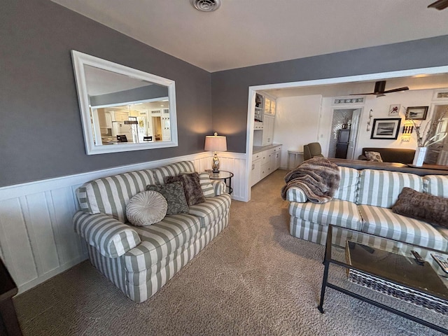 living room with light carpet, wainscoting, and visible vents