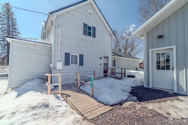 104 Birch St, Bergland, MI 49910 - snow covered rear of property with a deck and board and batten siding