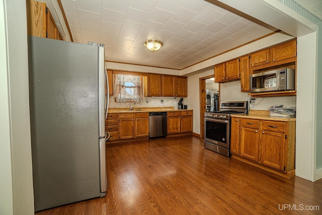 104 Birch St, Bergland, MI 49910 - kitchen featuring light countertops, brown cabinets, dark wood finished floors, stainless steel appliances, and a sink