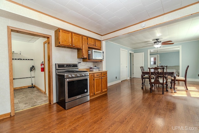 104 Birch St, Bergland, MI 49910 - kitchen featuring stainless steel appliances, light countertops, brown cabinetry, and a ceiling fan
