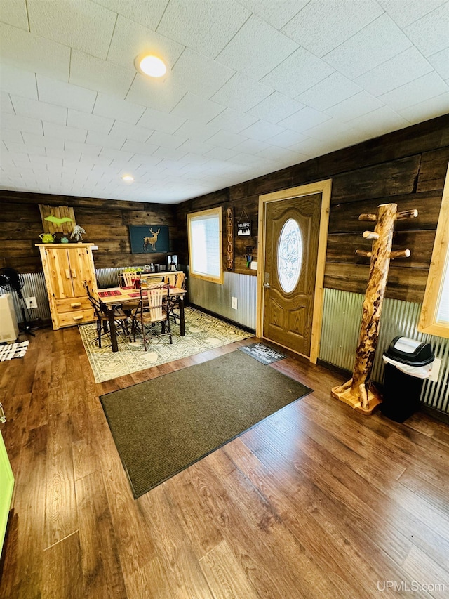foyer featuring wood finished floors and wooden walls