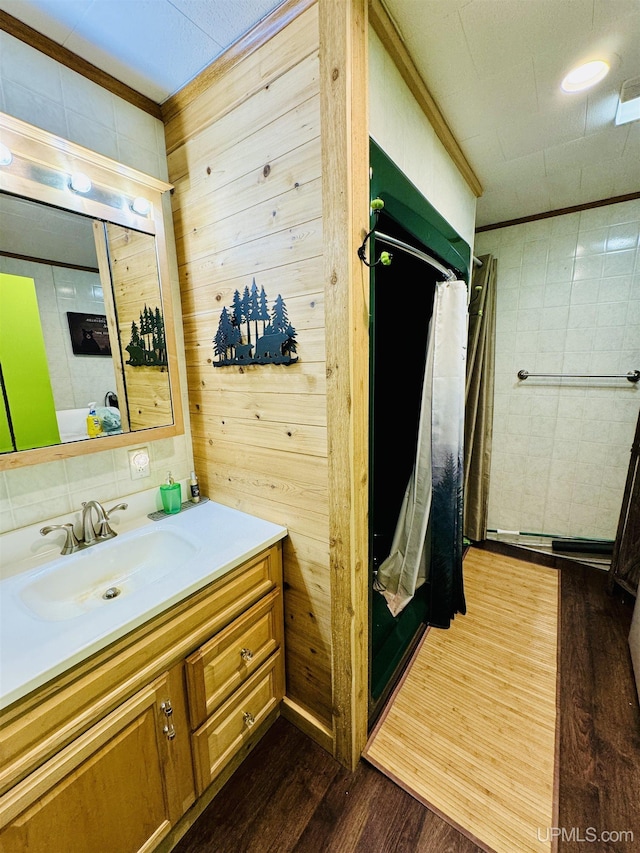 full bathroom with wooden walls, a shower with shower curtain, vanity, and wood finished floors