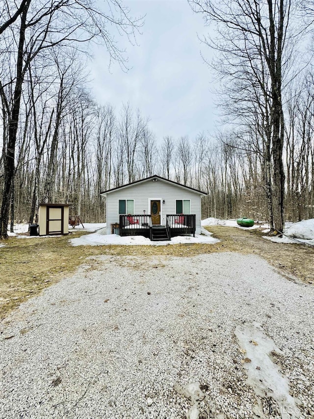 view of front facade featuring a storage shed, a deck, and an outdoor structure