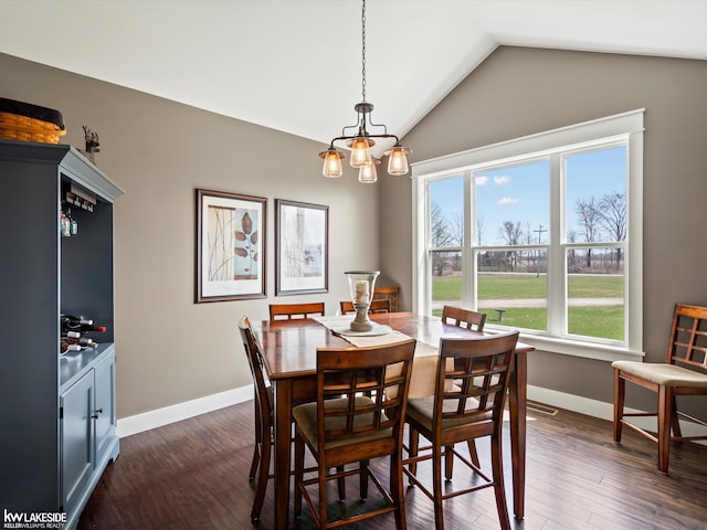 dining room featuring dark wood-style flooring, baseboards, an inviting chandelier, and lofted ceiling