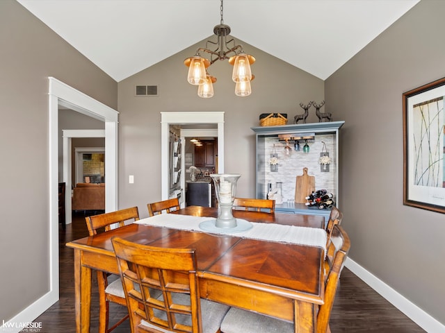 dining room featuring wood finished floors, visible vents, an inviting chandelier, and lofted ceiling
