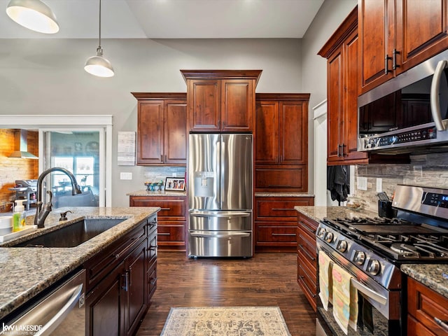 kitchen featuring wall chimney exhaust hood, light stone countertops, a sink, stainless steel appliances, and backsplash