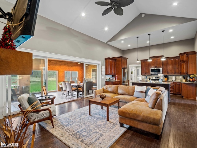 living room with recessed lighting, high vaulted ceiling, a ceiling fan, and dark wood-style flooring