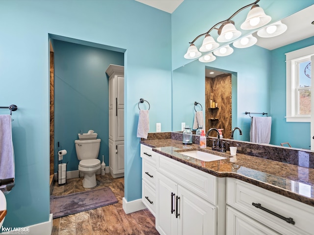 bathroom featuring vanity, baseboards, and toilet