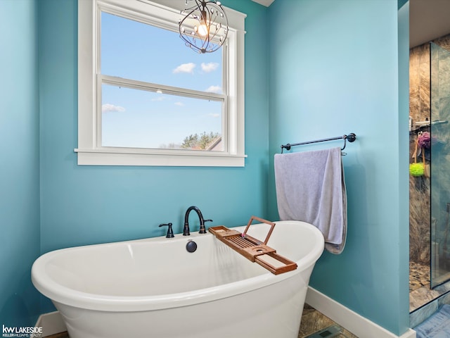 full bathroom with a freestanding bath, an enclosed shower, and baseboards