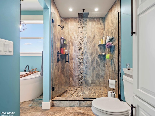 full bath featuring toilet, a freestanding bath, a stall shower, and recessed lighting