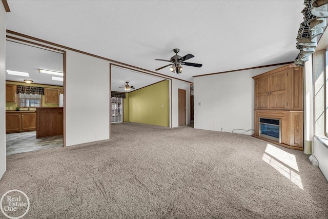 6240 Twin Lakes Dr, Kimball, MI 48074 - unfurnished living room featuring crown molding, light colored carpet, ceiling fan, and a large fireplace