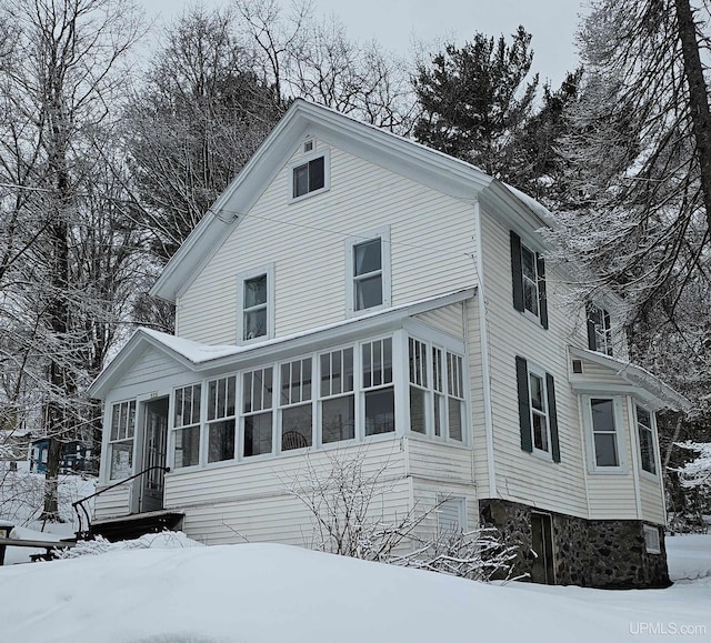 view of snow covered exterior featuring a sunroom