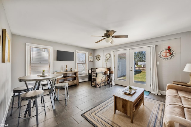 living room featuring french doors, a wealth of natural light, ceiling fan, and baseboard heating