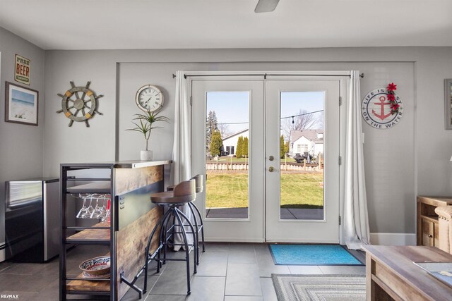 entryway featuring french doors, baseboards, and tile patterned flooring