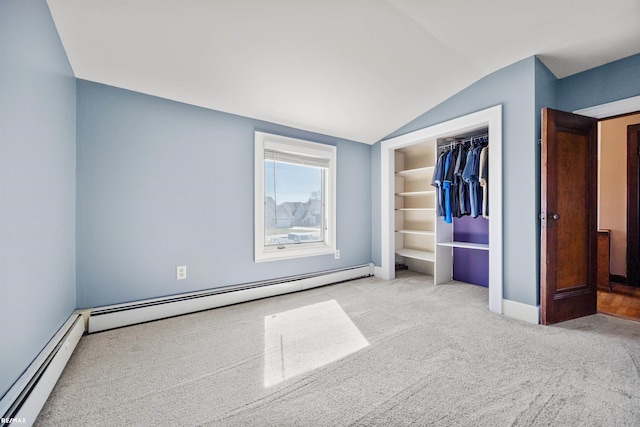 unfurnished bedroom featuring a baseboard heating unit, vaulted ceiling, and carpet floors