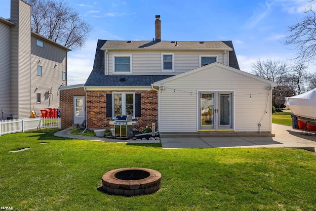 back of house featuring a patio area, a yard, fence, and an outdoor fire pit