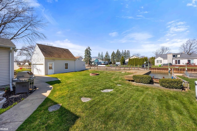 view of yard with an outdoor structure, fence, and a detached garage