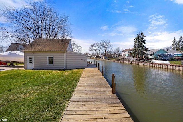 dock area with a lawn and a water view