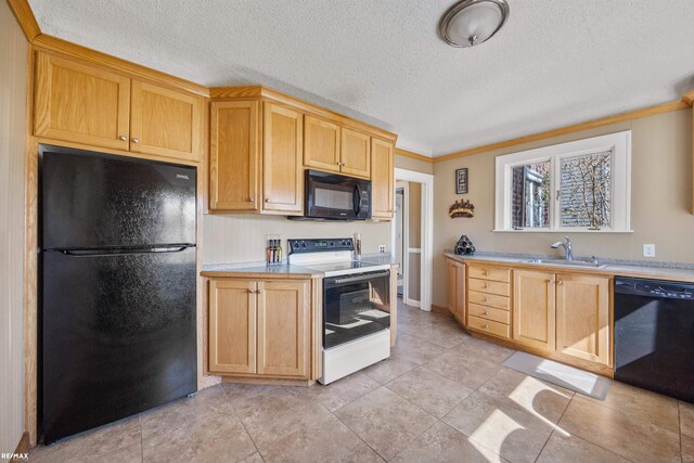 kitchen featuring light brown cabinets, light countertops, a textured ceiling, black appliances, and a sink