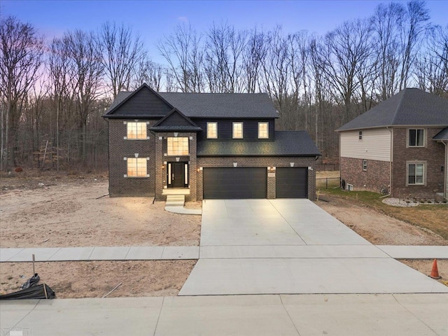 view of front of house featuring an attached garage, concrete driveway, and brick siding