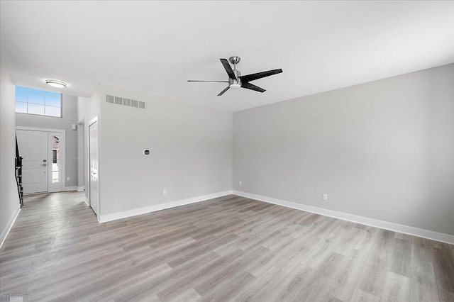 empty room with light wood finished floors, visible vents, baseboards, and a ceiling fan