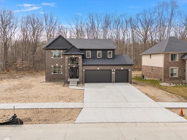 traditional-style house with brick siding, an attached garage, a shingled roof, and driveway