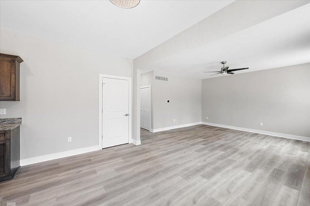 unfurnished living room with visible vents, baseboards, a ceiling fan, and light wood-style flooring