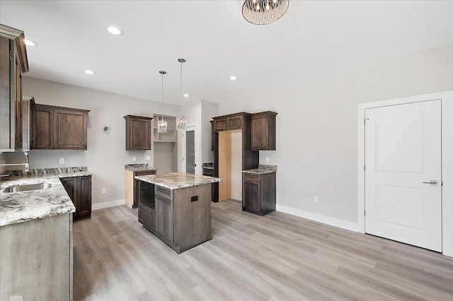 kitchen with light wood-style flooring, dark brown cabinets, recessed lighting, a sink, and baseboards