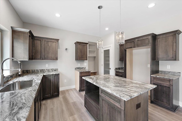 kitchen with light wood-type flooring, open shelves, a chandelier, a sink, and baseboards