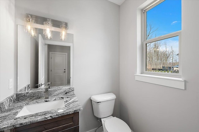 half bath featuring vanity and toilet