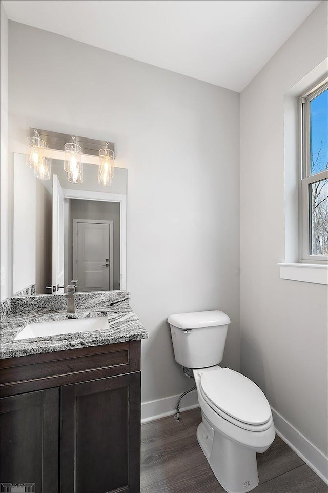 bathroom featuring vanity, baseboards, toilet, and wood finished floors