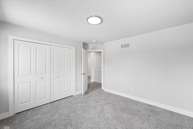 unfurnished bedroom with a closet, visible vents, baseboards, and carpet floors