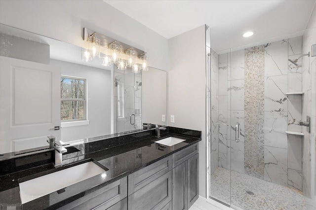 full bath with double vanity, a marble finish shower, a sink, and recessed lighting