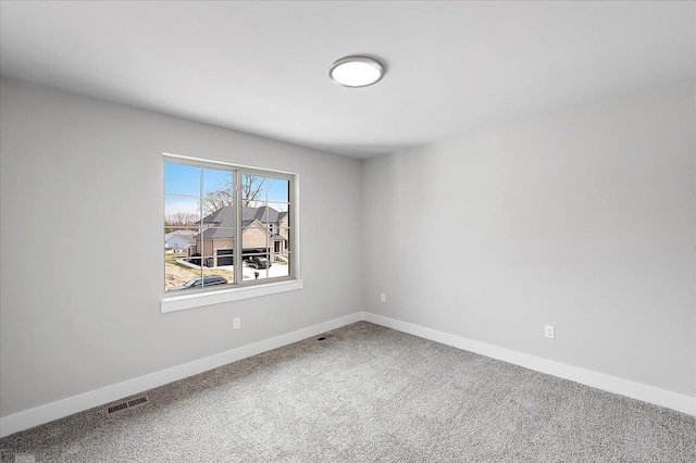 carpeted empty room with visible vents and baseboards