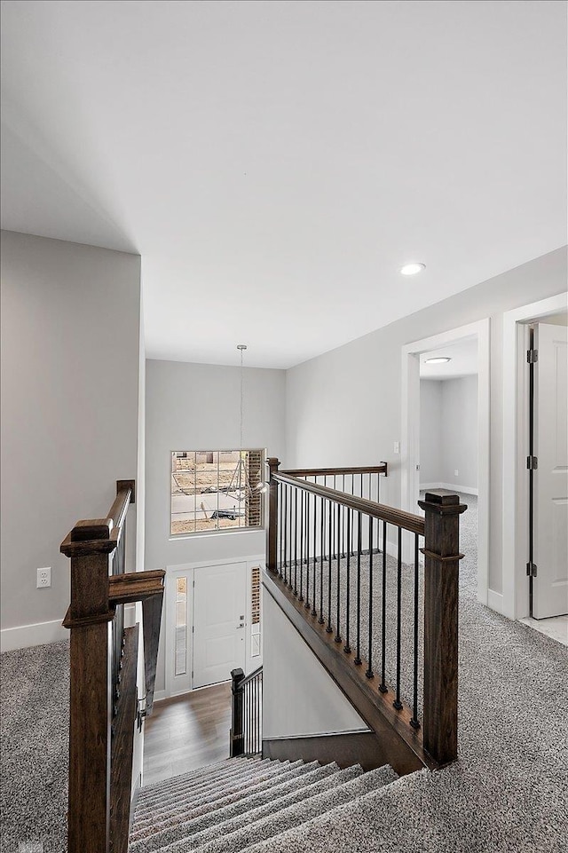 stairway featuring baseboards, recessed lighting, and carpet