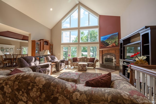 living room featuring high vaulted ceiling and a fireplace with raised hearth