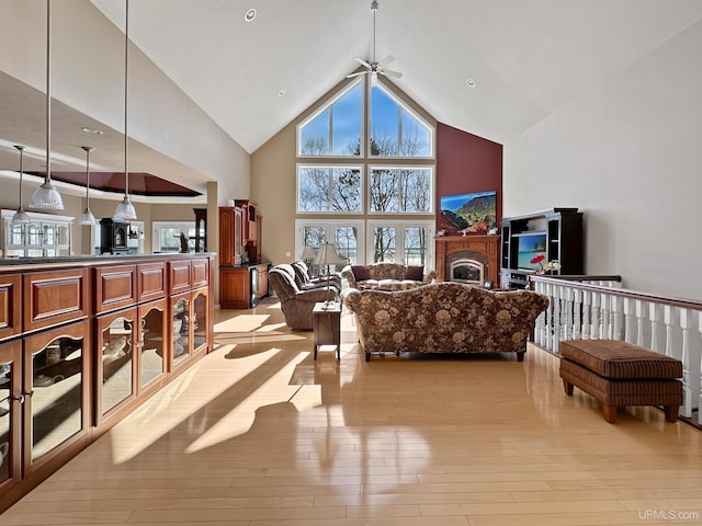 living area featuring light wood-style floors, high vaulted ceiling, and a wealth of natural light