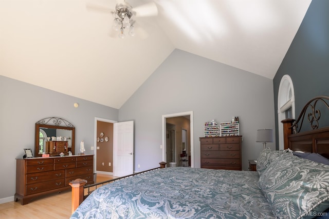 bedroom with high vaulted ceiling, light wood-type flooring, and baseboards