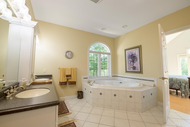 ensuite bathroom with tile patterned floors, plenty of natural light, and a sink