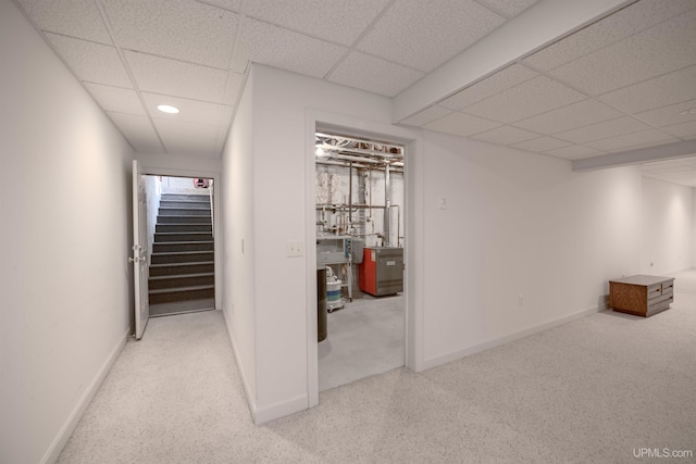interior space with stairs, carpet, a drop ceiling, and baseboards