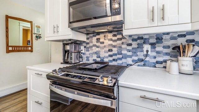 kitchen featuring a baseboard heating unit, white cabinetry, light countertops, decorative backsplash, and appliances with stainless steel finishes