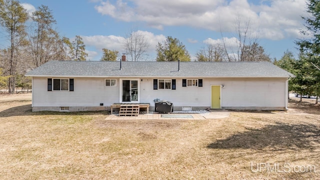 back of house featuring a shingled roof and a lawn