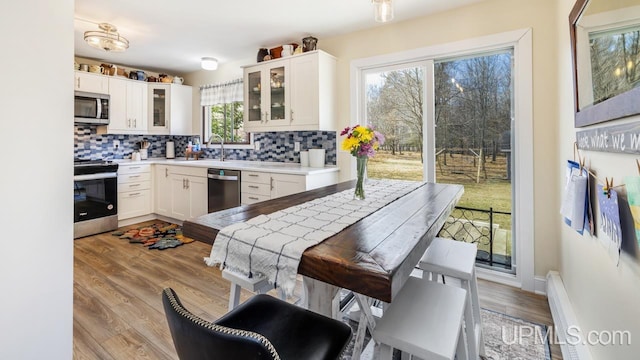 kitchen featuring white cabinetry, a sink, backsplash, and stainless steel appliances