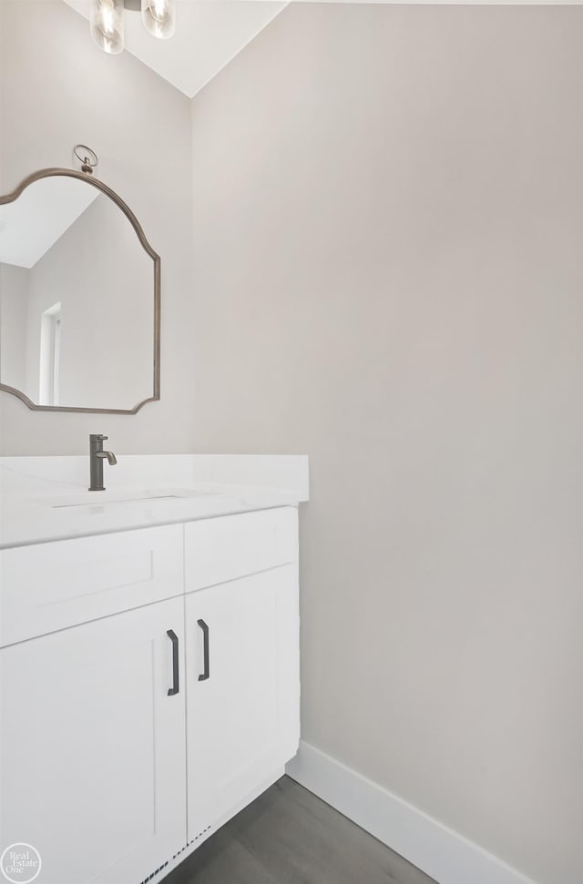 bathroom featuring baseboards, vanity, and wood finished floors