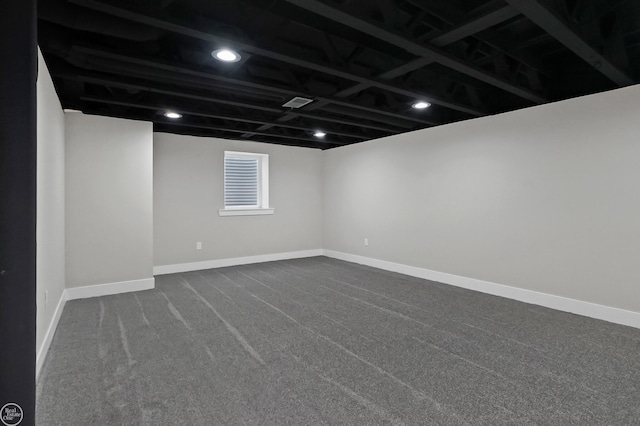unfurnished room featuring baseboards and dark colored carpet