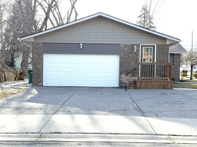 exterior space featuring concrete driveway, an attached garage, and brick siding