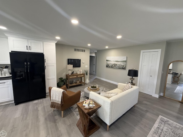 living room with baseboards, light wood-style floors, visible vents, and recessed lighting