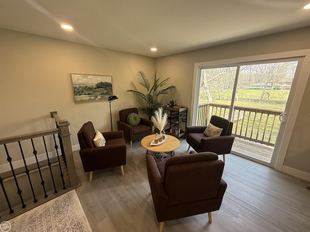 living room featuring baseboards, wood finished floors, and recessed lighting