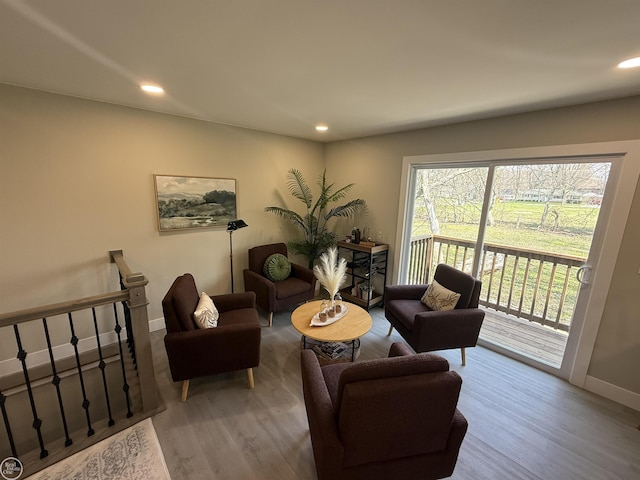 living room featuring baseboards, wood finished floors, and recessed lighting